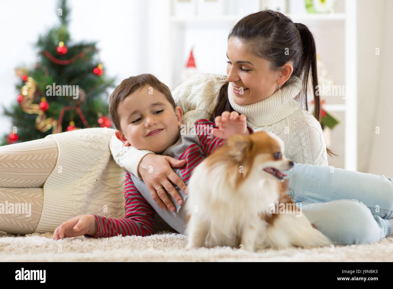 Famille avec le chien à l'arbre de Noël Banque D'Images