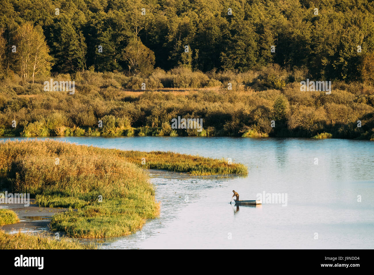 Pêche à l'homme de l'ancien bateau de pêche en bois en été, lac ou rivière. Belle journée ensoleillée d'été ou en soirée. La nature russe. L'écotourisme. Banque D'Images