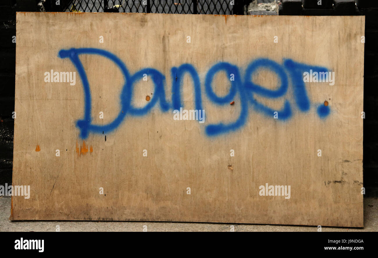 Le signe de danger à l'encre bleue sur planche de bois Banque D'Images