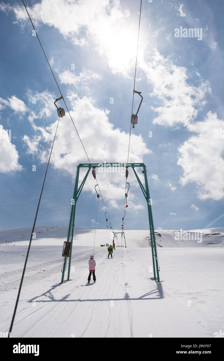 Petite fille aux débutant skis monte avec téléskis Banque D'Images