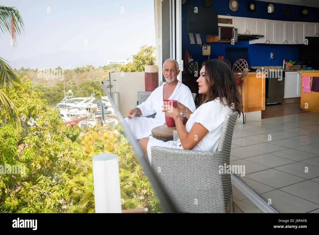 Couple assis sur un balcon donnant sur le port de plaisance de Nuevo Vallarta, Nayarit, Mexique Banque D'Images