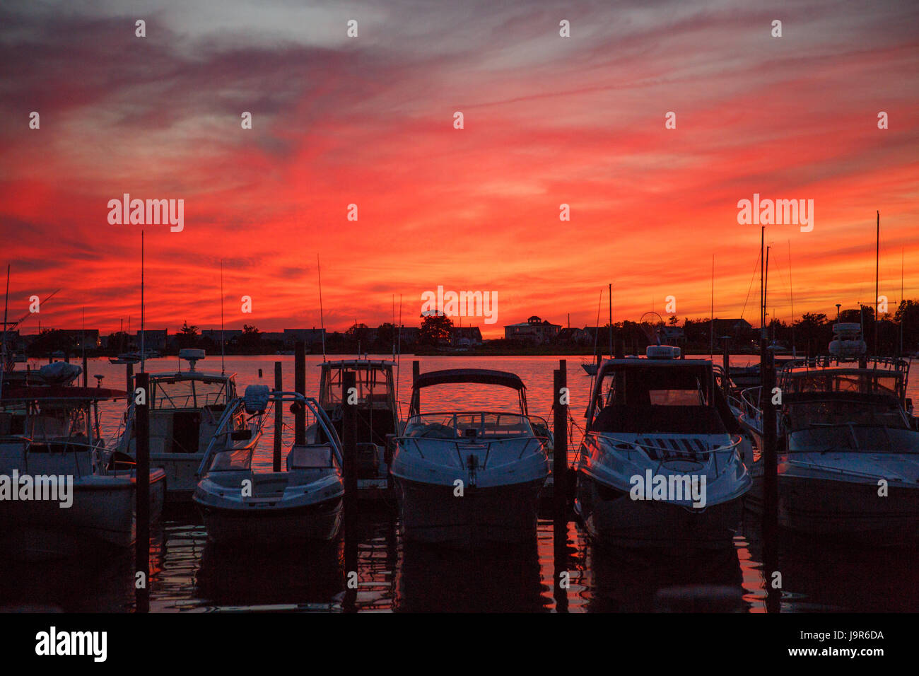 Vue du coucher de soleil à Sag Harbor dans les Hamptons avec les bateaux à moteur sur le quai, Banque D'Images