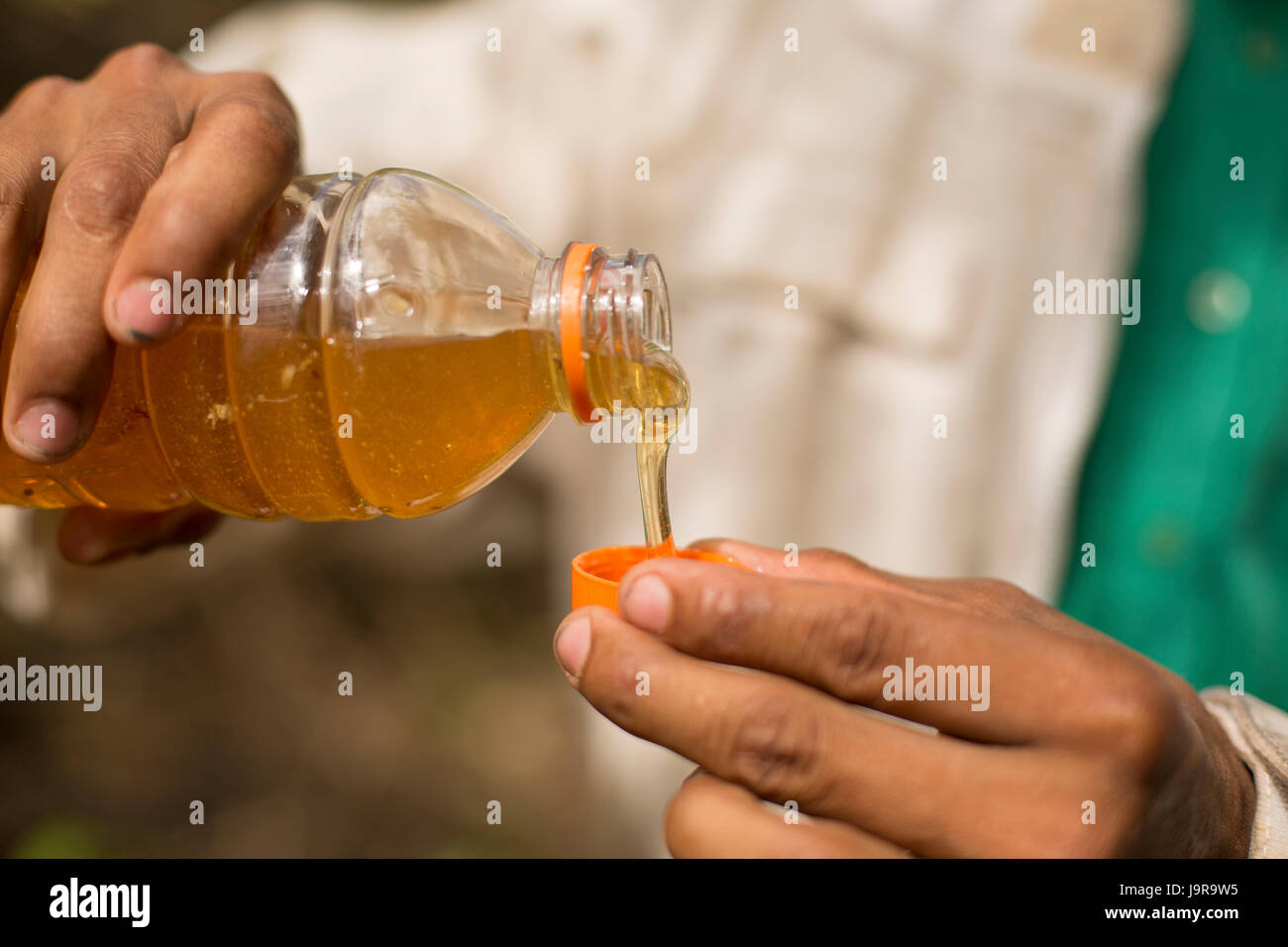 Un agriculteur du miel fraîchement récolté quelques échantillons de miel à Léon Ministère, le Nicaragua. Banque D'Images