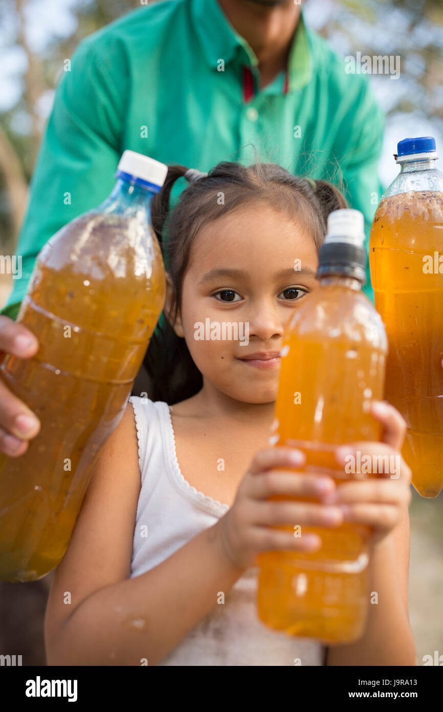 Une fille est titulaire d'un miel récolté sur sa ferme dans la région de Léon, Département du Nicaragua. Banque D'Images
