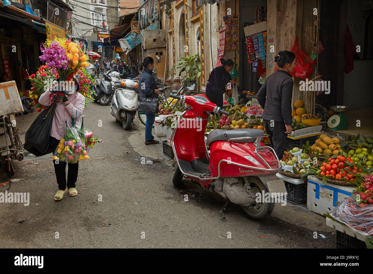 Vendeuse de fleurs et les motos, vieux quartier, Hanoi, Vietnam Banque D'Images