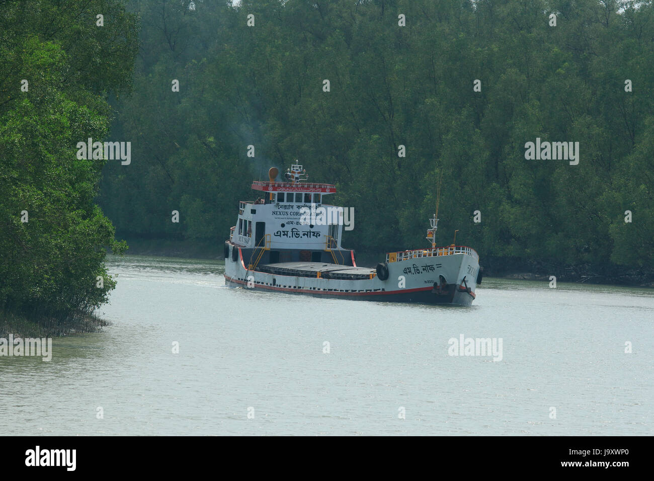 Un bateau navigue à proximité de la banque d'Shibsha rivière à l'intérieur les Sundarbans en dépit des risques écologiques. Satkhira, Bangladesh Banque D'Images