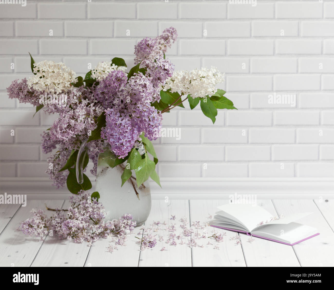 Magnifique bouquet de lilas blanc et violet fleurs dans vase en verre avec  ouvert note-book sur la brique et bois blanc arrière-plan Photo Stock -  Alamy