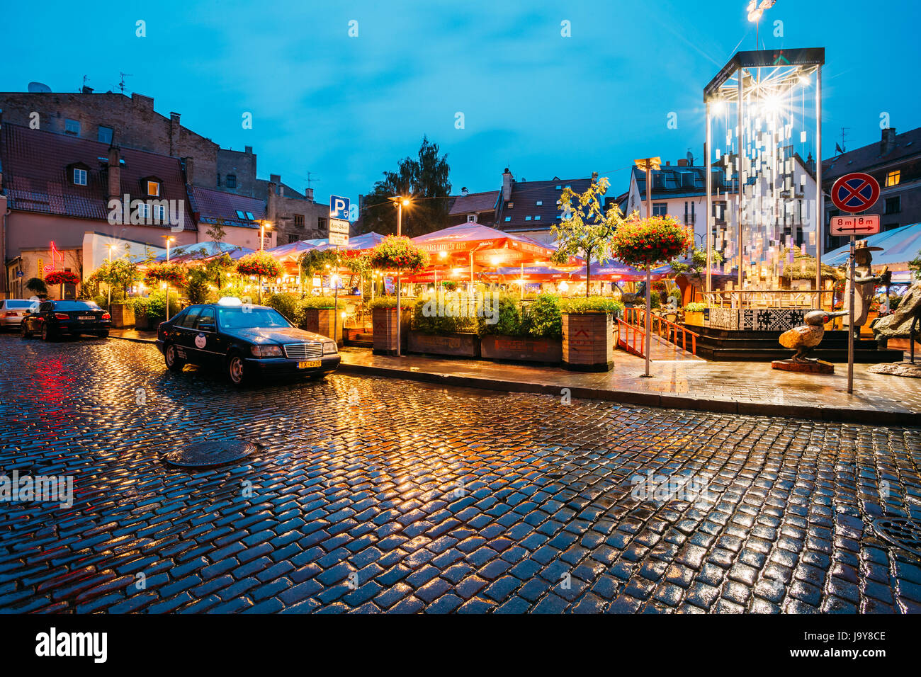 Riga, Lettonie - Juillet 3, 2016 : Taxi Voiture Mercedes-Benz W140 Clients attendre près de Open Air Lieu de loisirs centre de loisirs Egle en soirée ou la nuit Illuminat Banque D'Images