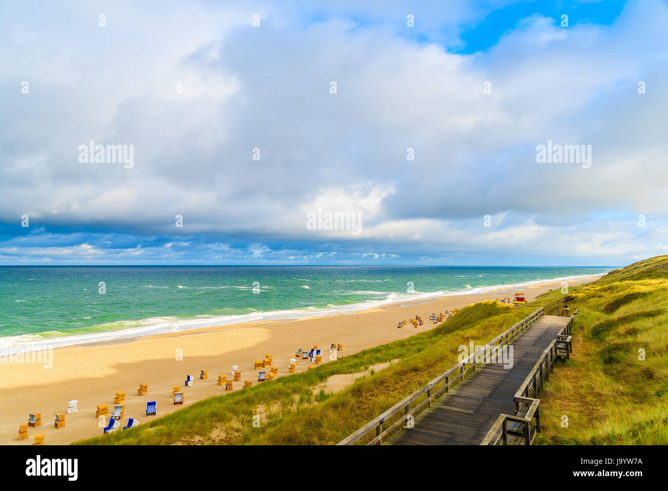 Promenade le long du littoral plage Wenningstedt au lever du soleil, l'île de Sylt, en mer du Nord, Allemagne Banque D'Images