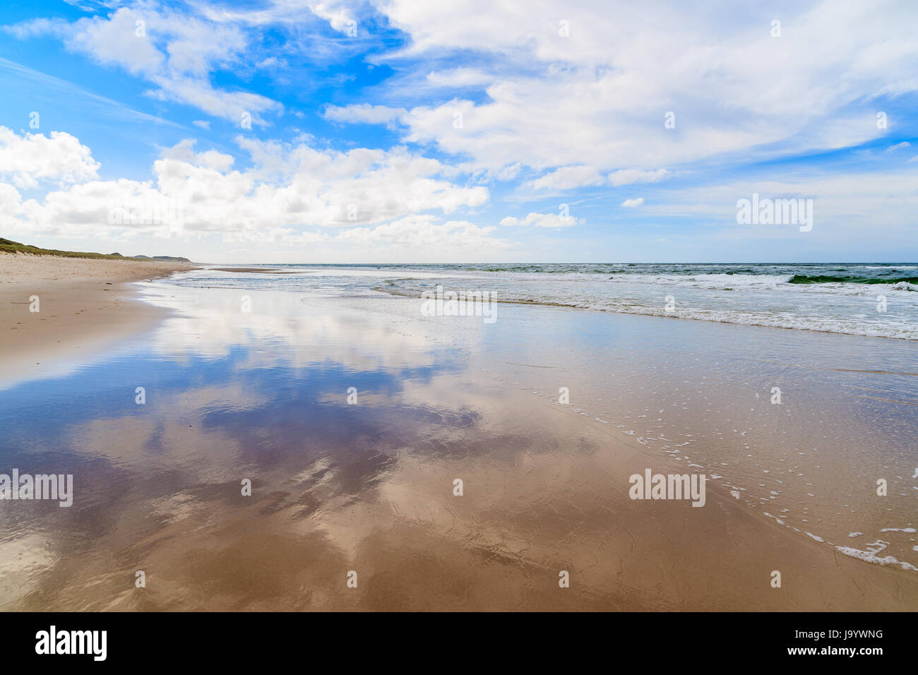Le sable humide et les nuages réflexions sur la plage de l'île de Sylt, Liste, Mer du Nord, Allemagne Banque D'Images