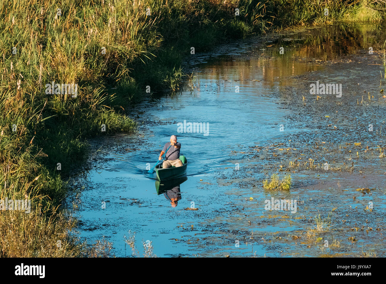 Gomel, Bélarus - 6 septembre 2016 : Man Fishing de l'ancien bateau de pêche en bois en été, lac ou rivière. Belle journée ensoleillée d'été ou en soirée. Fédération N Banque D'Images