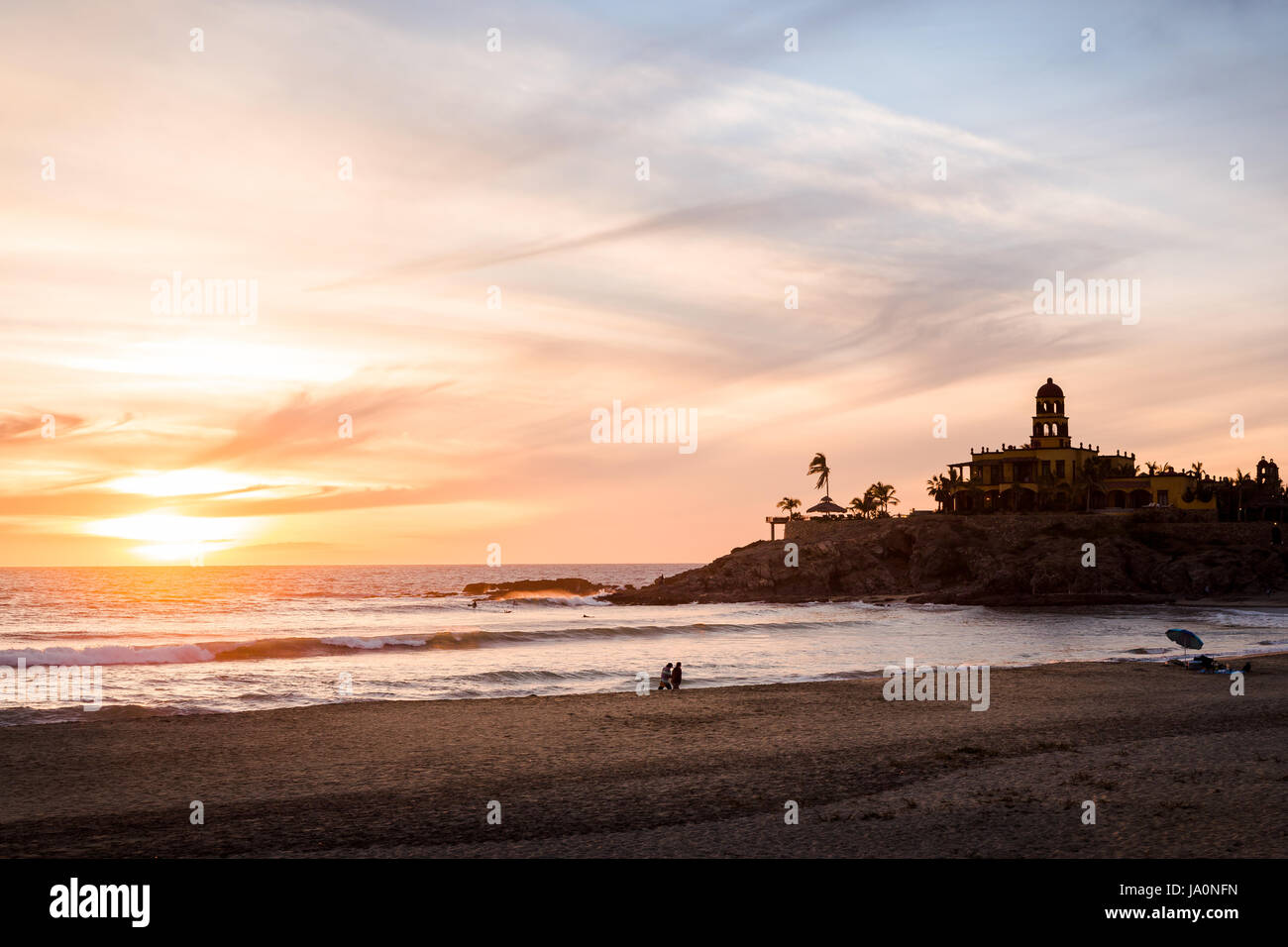 Un groupe d'amis marche sur Cerritos Beach au coucher du soleil. Banque D'Images