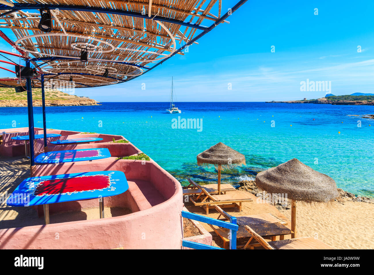 Vue sur Cala Comte plage avec chaises longues et parasols sur la plage, l'île d'Ibiza, Espagne Banque D'Images