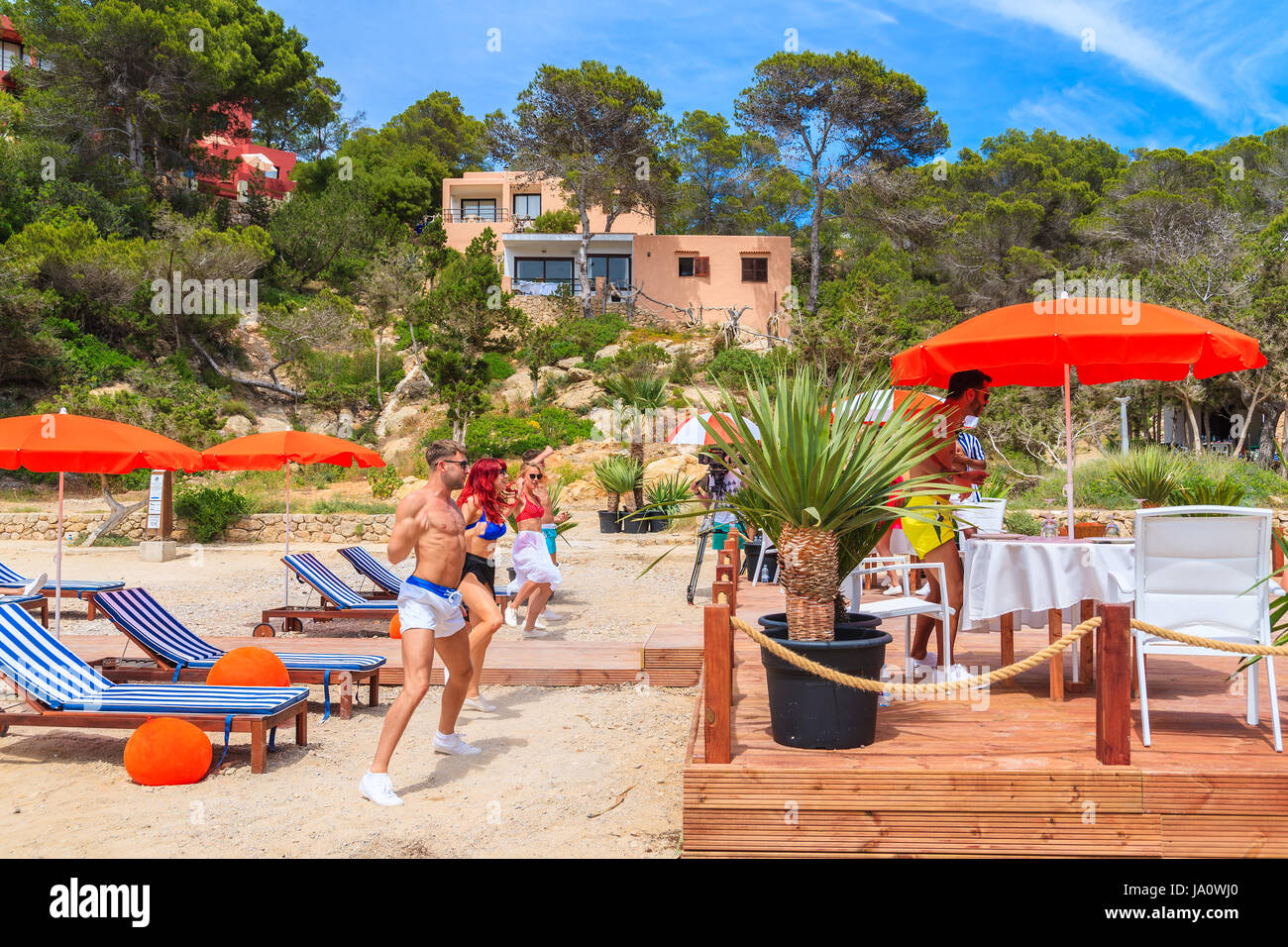 L'île d'Ibiza, ESPAGNE - 17 MAI 2017 : jeunes dansant sur terrasse de restaurant de la plage à Cala Carbo alors qu'ils sont filmés en vue de produire Banque D'Images