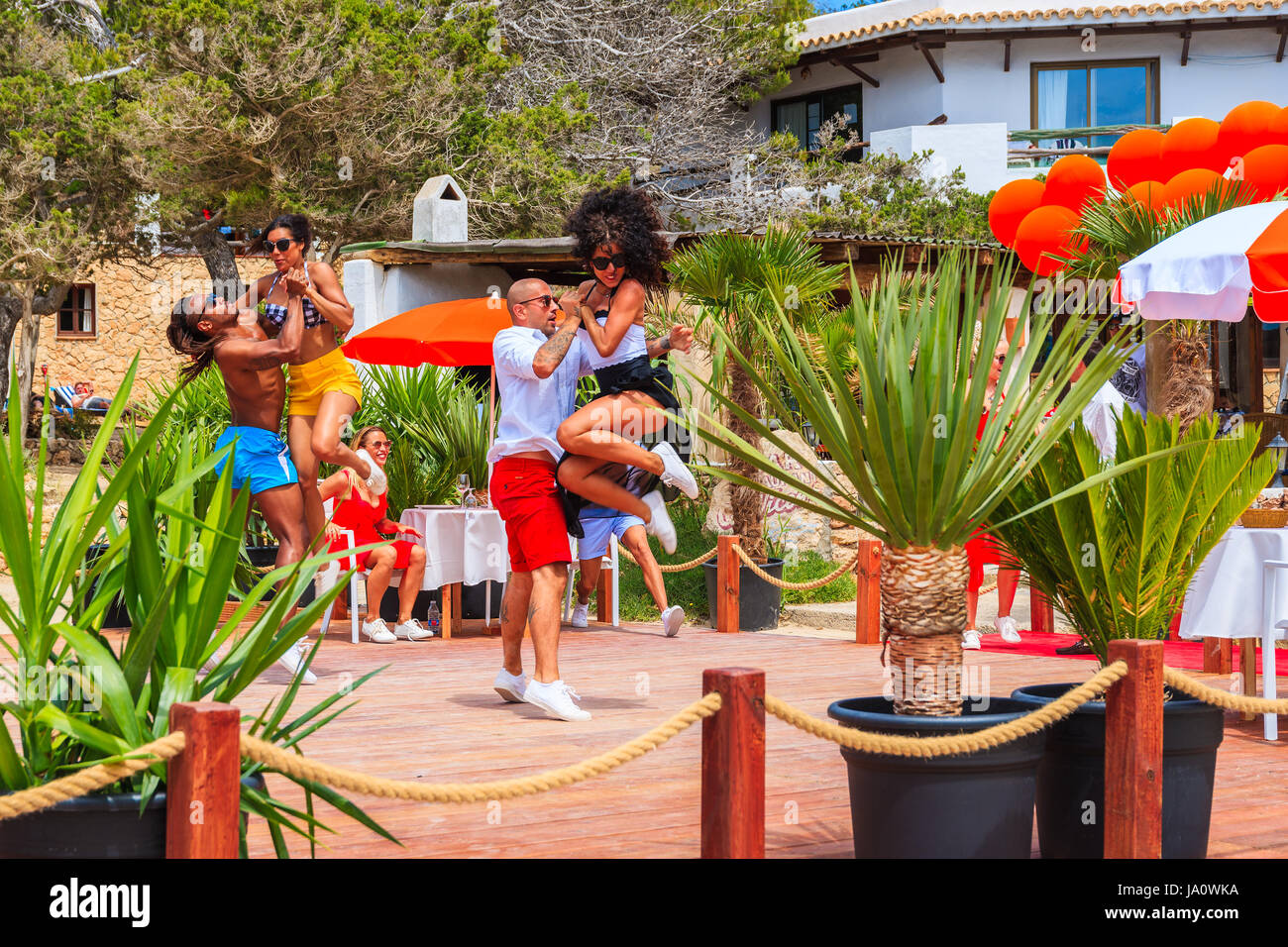 L'île d'Ibiza, ESPAGNE - 17 MAI 2017 : jeunes dansant sur terrasse de restaurant de la plage à Cala Carbo alors qu'ils sont filmés en vue de produire Banque D'Images