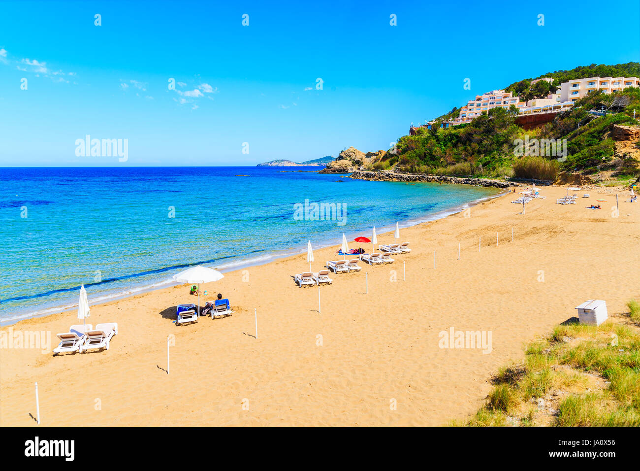 Vue sur plage de Es Figueral avec transats et parasols, l'île d'Ibiza, Espagne Banque D'Images