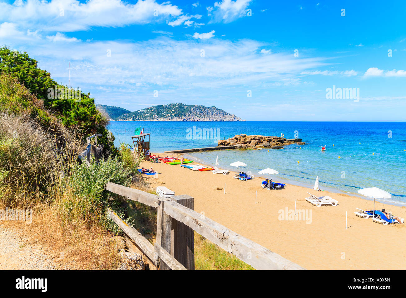 Vue sur plage de Es Figueral avec transats et parasols, l'île d'Ibiza, Espagne Banque D'Images