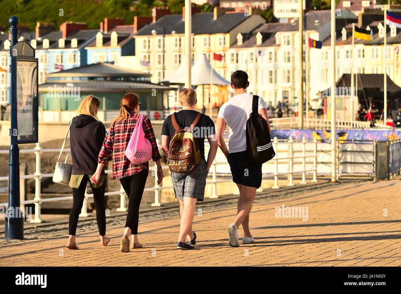 Aberystwyth . Wales U.K. Dimanche 04 Juin 2017 Royaume-Uni Météo : les gens marcher sur la promenade à Aberystwyth au Pays de Galles sur un brillant mais breezy dimanche soir. Le temps est réglé à changer du jour au lendemain, avec une période de forte pluie prévision pour la semaine Photo : Keith Morris / Alamy Live News Banque D'Images
