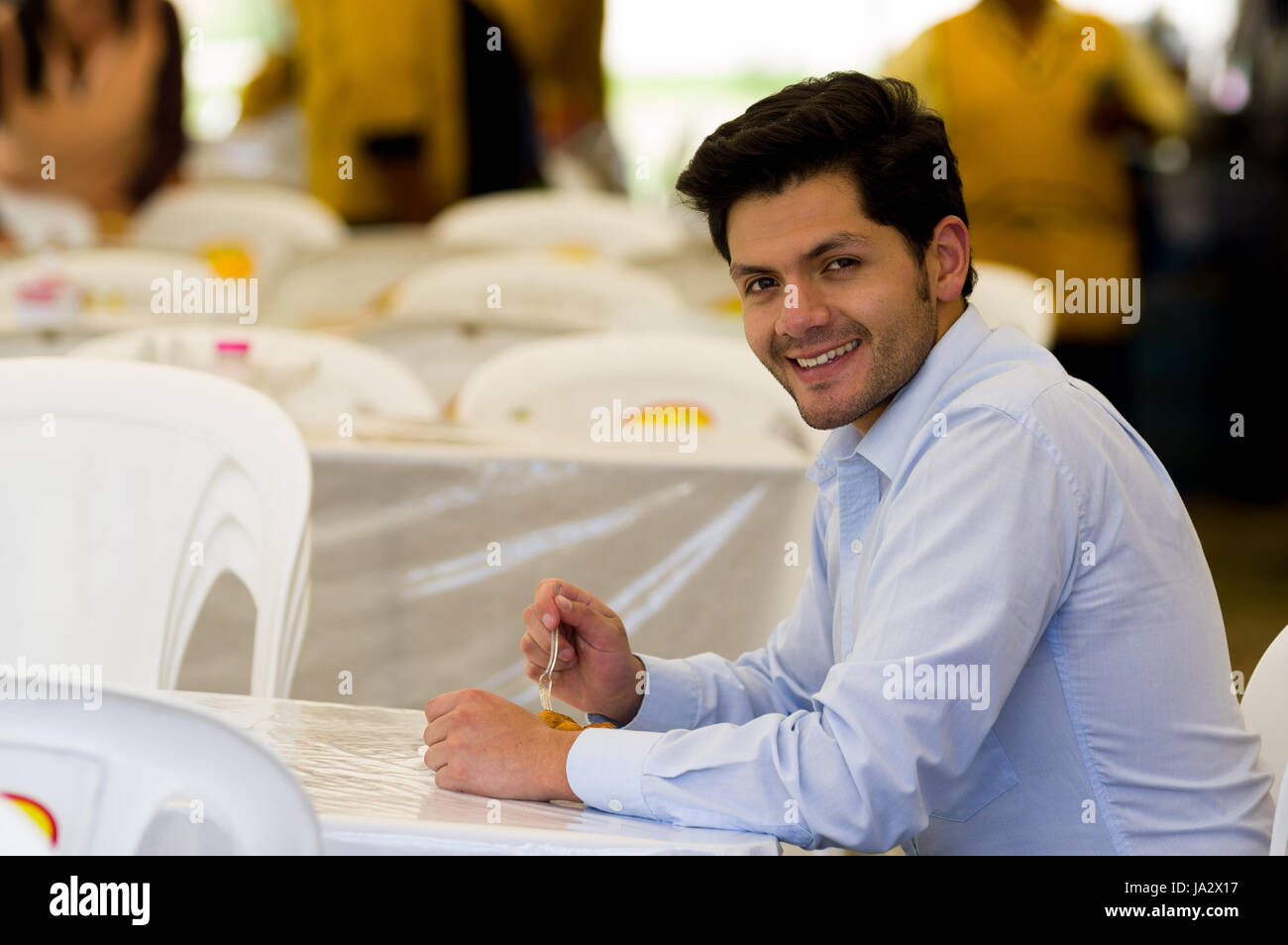 Beau jeune businessman eating a des beignets avec du sucre et de ses composants Banque D'Images