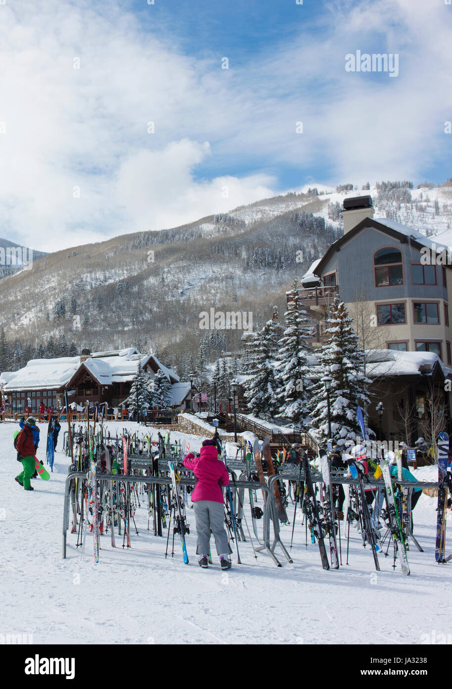 Un skieur s'occupe de skis à un rack à Beaver Creek, une station de ski à proximité de Avon, Colorado. Banque D'Images