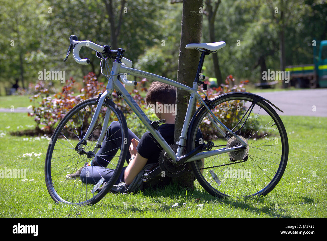 Glasgow parc Kelvingrove cycliste scènes texting Banque D'Images