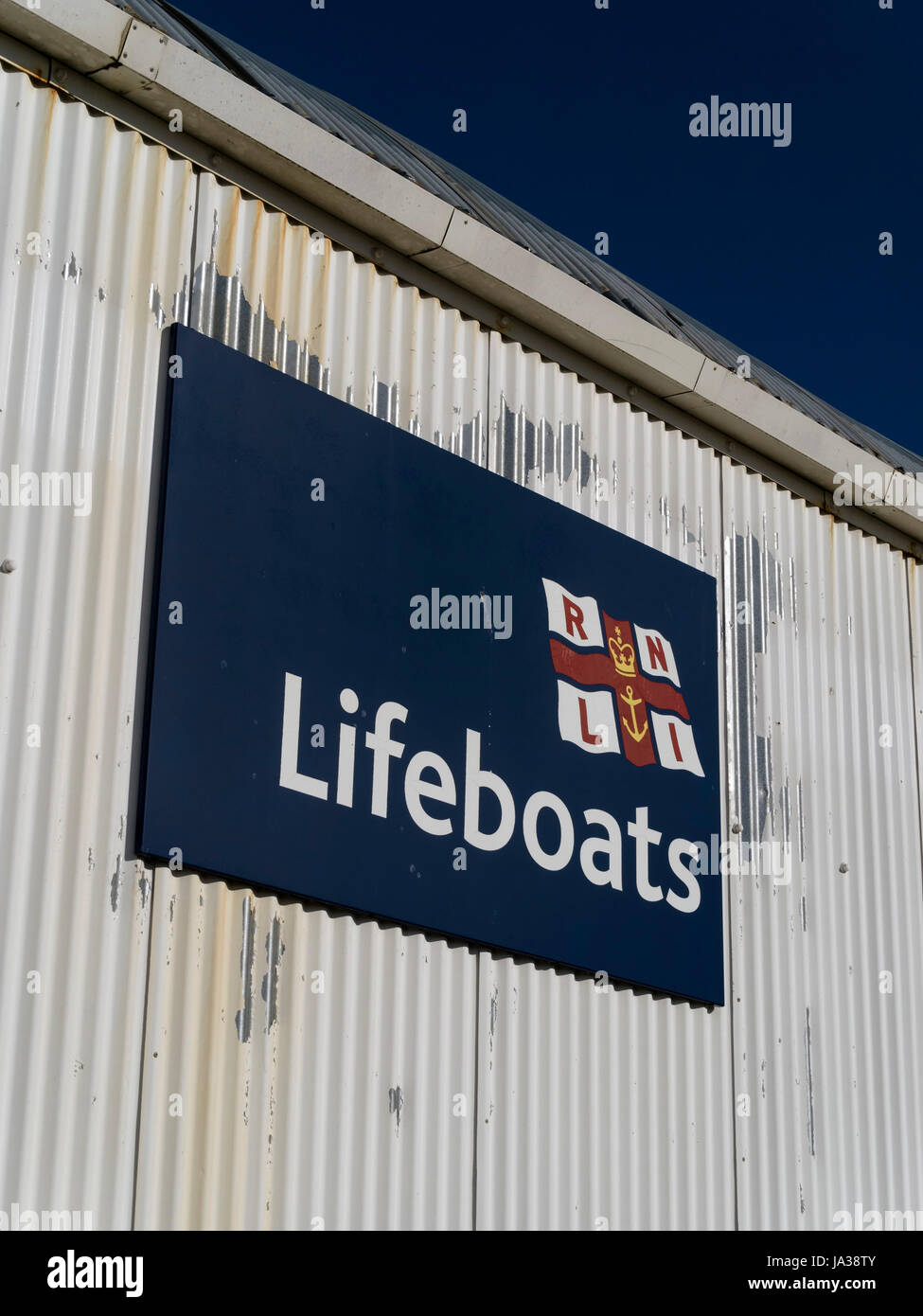 Signe de sauvetage de la RNLI sur le côté de la tôle ondulée peinte en blanc construction station de sauvetage, Eastbourne, East Sussex, England, UK Banque D'Images