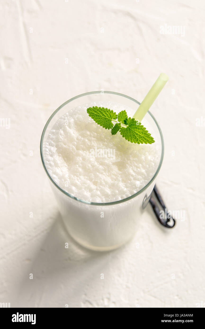 Shake vanille à la menthe sur fond blanc. Glace vanille Milk Shake. Smoothie banane avec la menthe et la vanille. Banque D'Images