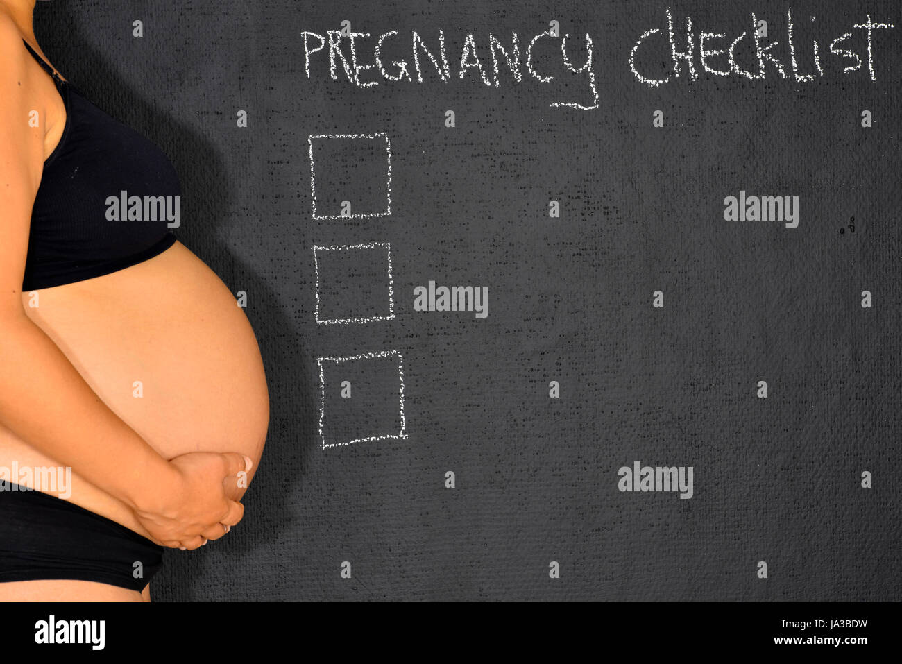 Une femme enceinte est debout à côté d'une feuille de la grossesse avec  l'espace pour écrire Photo Stock - Alamy