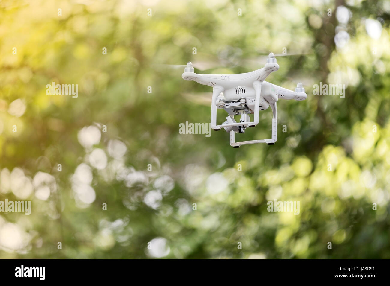 Bourdon blanc quad copter avec appareil photo numérique haute résolution volant dans le ciel bleu ,soft focus Banque D'Images