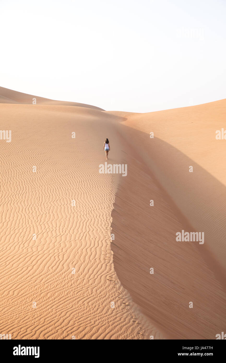 Belle femme randonnée sur les dunes de sable géantes. Désert de Liwa, eau. Banque D'Images