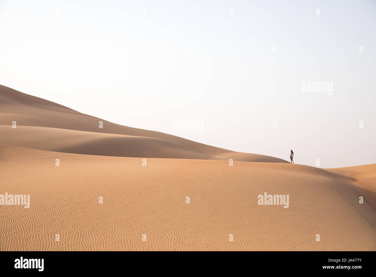 Belle femme randonnée sur les dunes de sable géantes. Désert de Liwa, eau. Banque D'Images