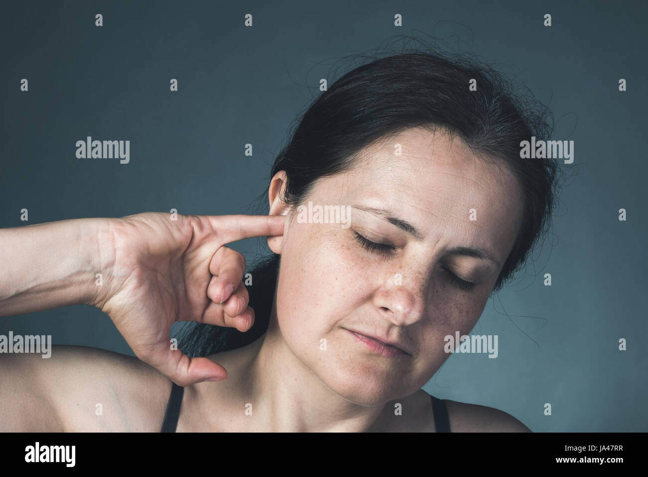 Une femme qui a mal aux oreilles Banque D'Images