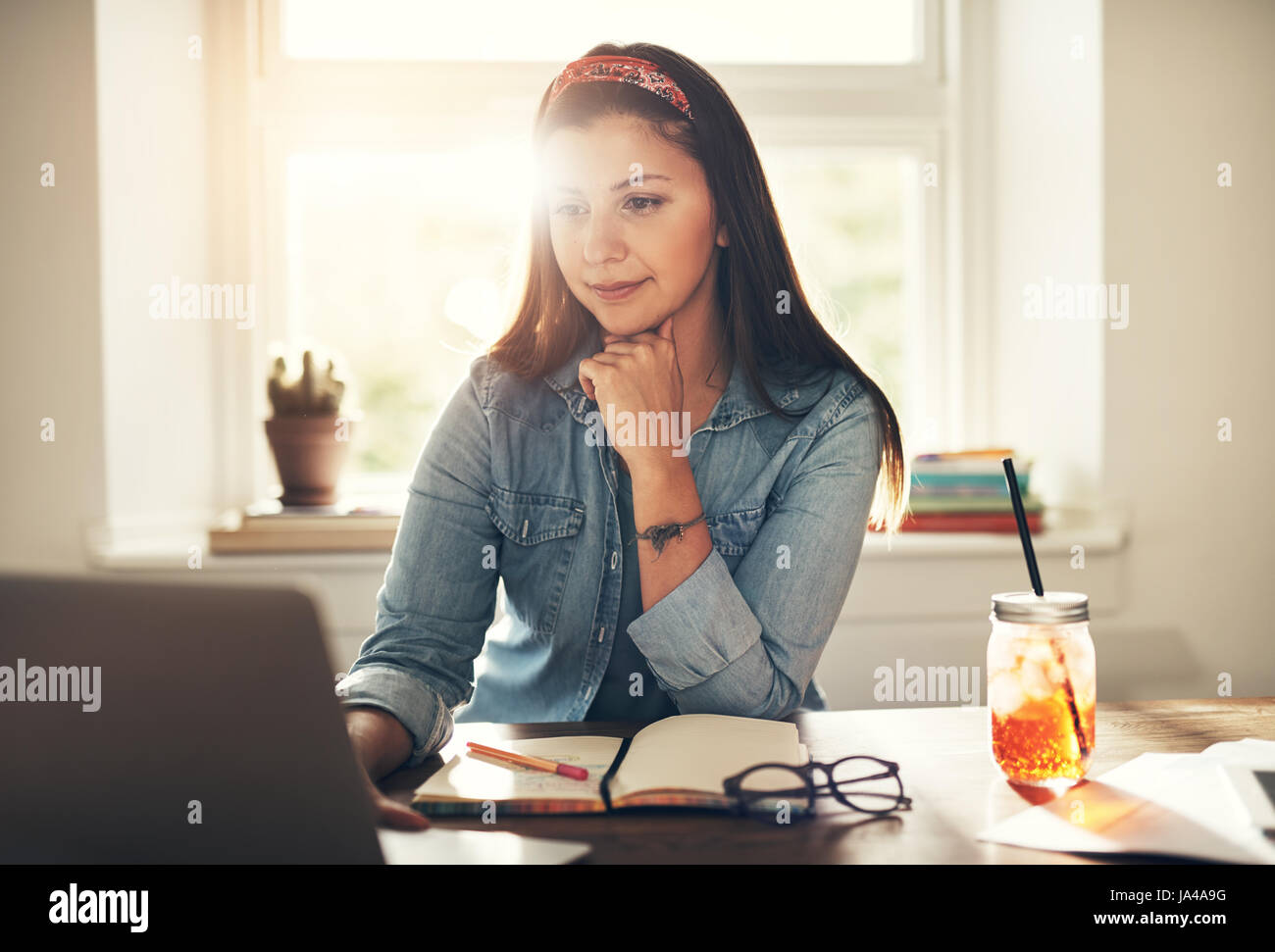 Jeune femme entrepreneur assis et de navigation à l'ordinateur au travail. Banque D'Images