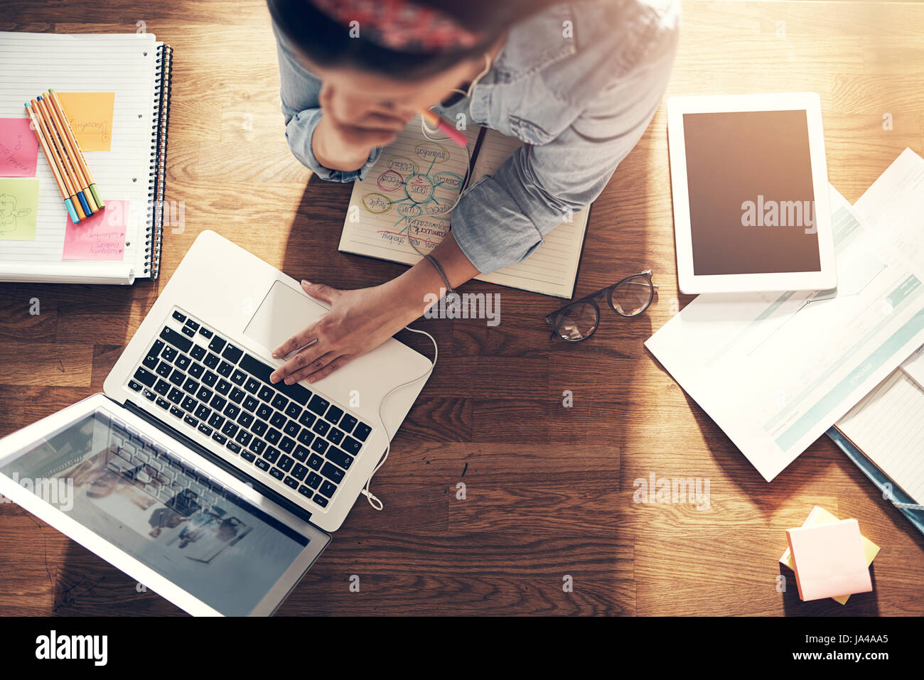 Au-dessus de la femme entrepreneur et ordinateur portable navigation holding pencil en pensant au laptop in office. Banque D'Images
