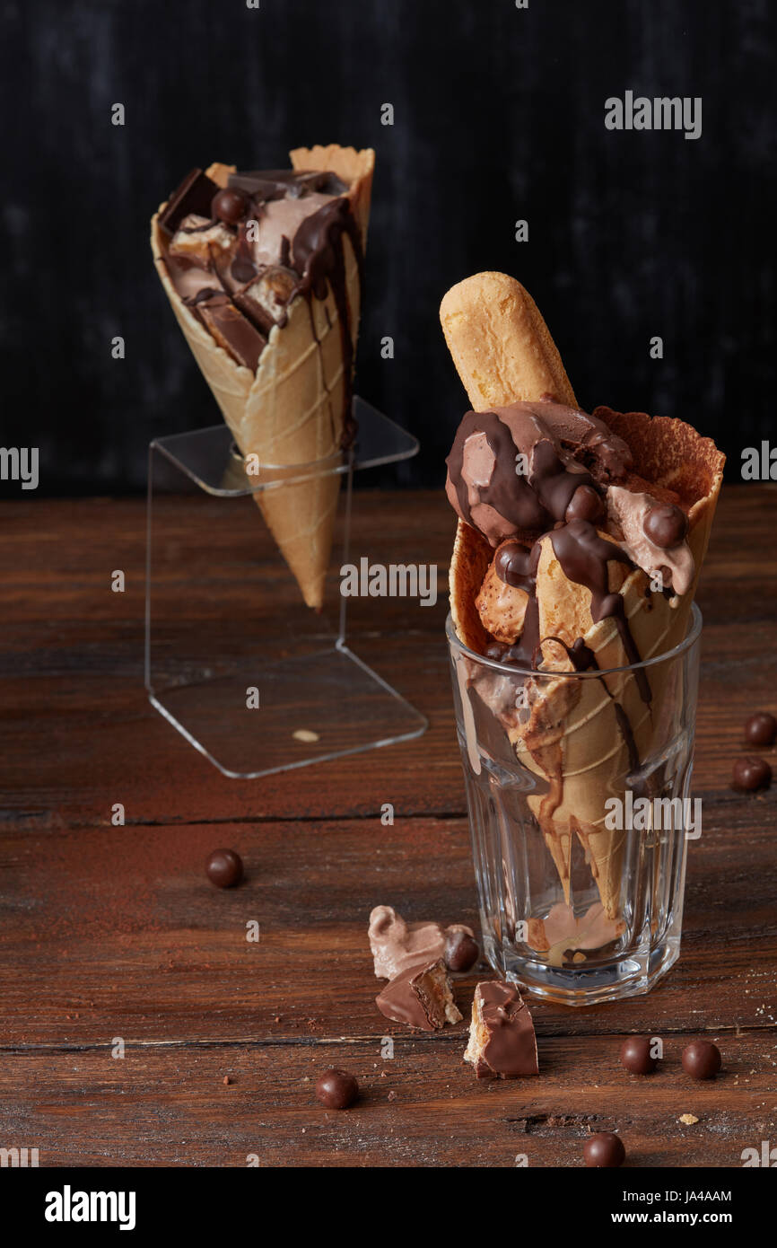 Glaces en cornet gaufré dans un verre et sur un stand d'une savoureuse  crème glacée , biscuits bonbons Chocolat et mise sur un fond brun en bois  Photo Stock - Alamy