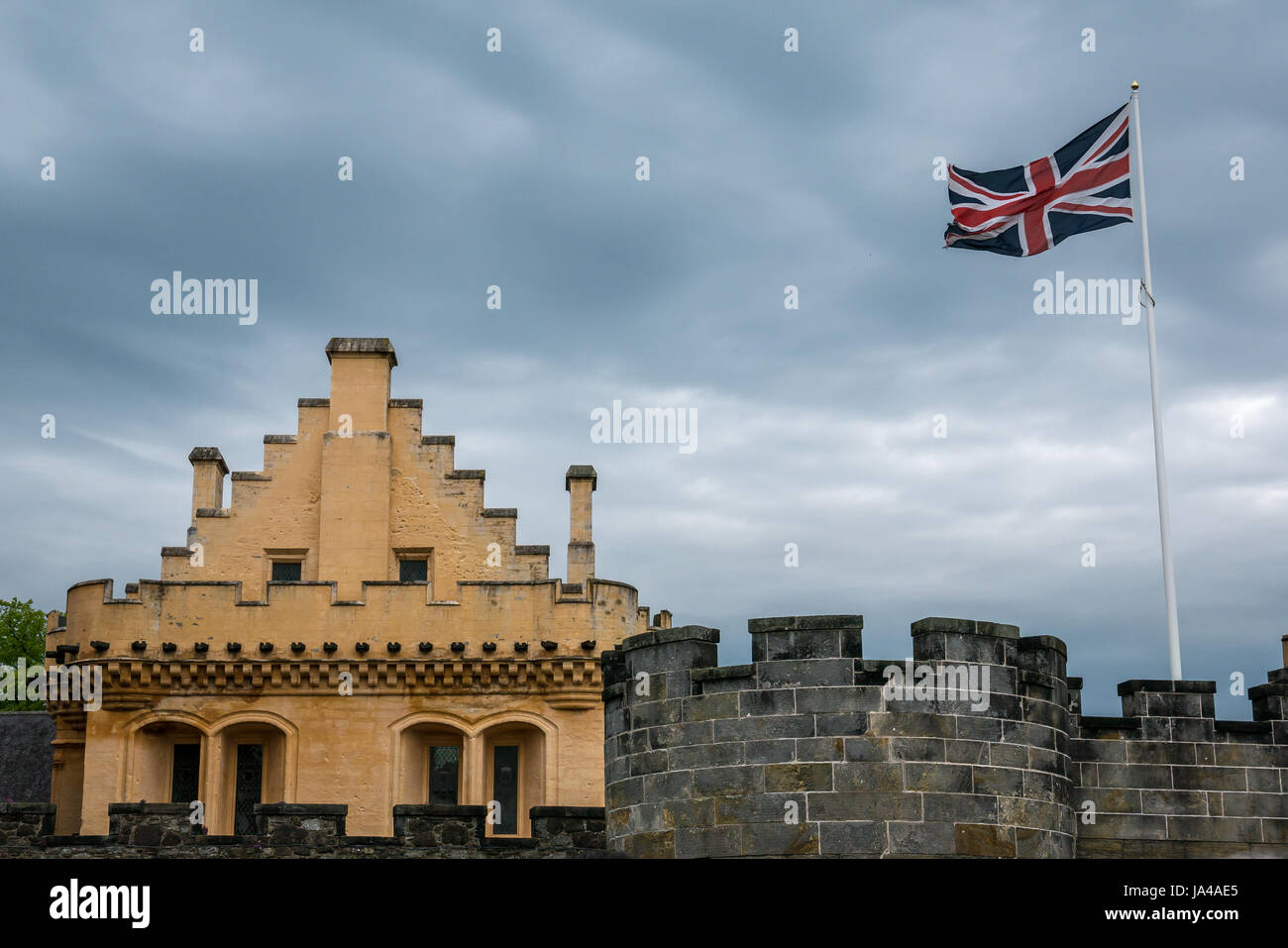 La chaux jaune lavé grande salle et remparts du château avec moody ciel gris et Union Jack flag flying, le château de Stirling, Stirling, Scotland, UK Banque D'Images