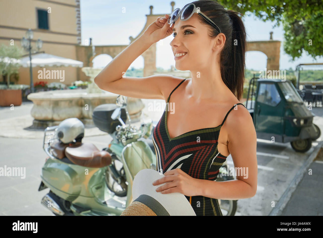 Belle jeune femme italienne vintage assis sur un scooter. Banque D'Images