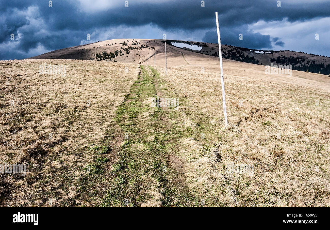 Ploska hill avec mountain meadow, sentier de randonnée, peu de petits champs de neige et ciel bleu avec des nuages sombres au printemps dans les montagnes Velka Fatra Slovaquie Banque D'Images