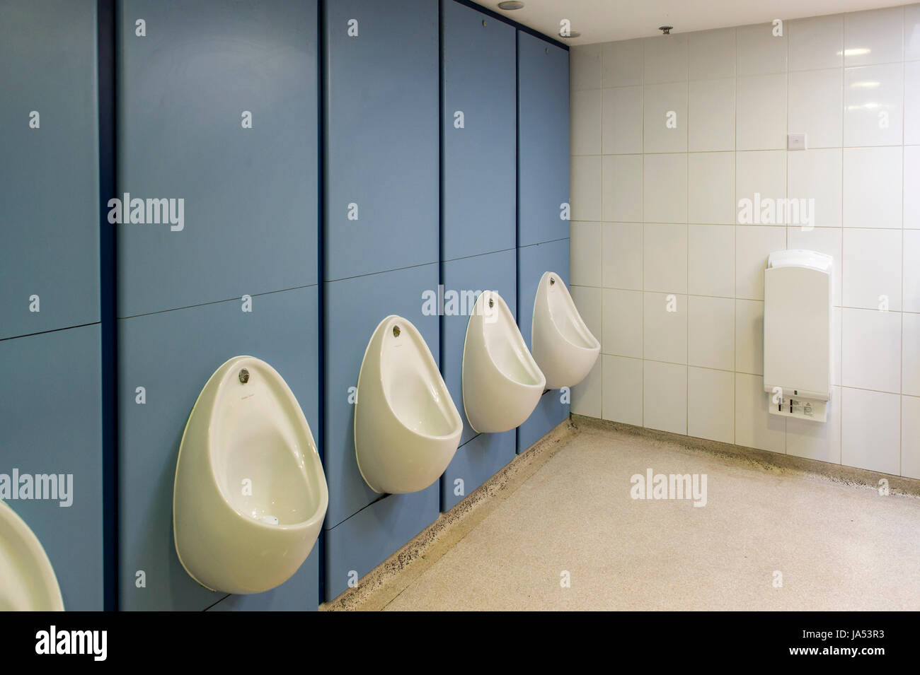 Intérieur d'une toilette de gents dans un centre commercial avec urinoirs et sèche-mains. Banque D'Images