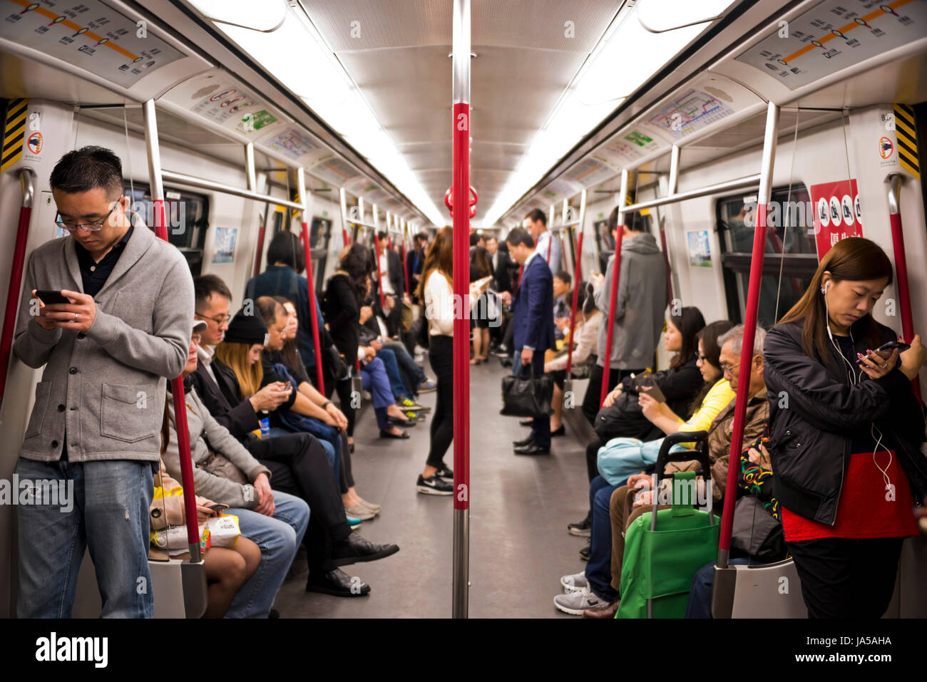 Vue horizontale de passagers à l'intérieur de l'EXAMEN À MI-PARCOURS, Mass Transit Railway, à Hong Kong, Chine. Banque D'Images