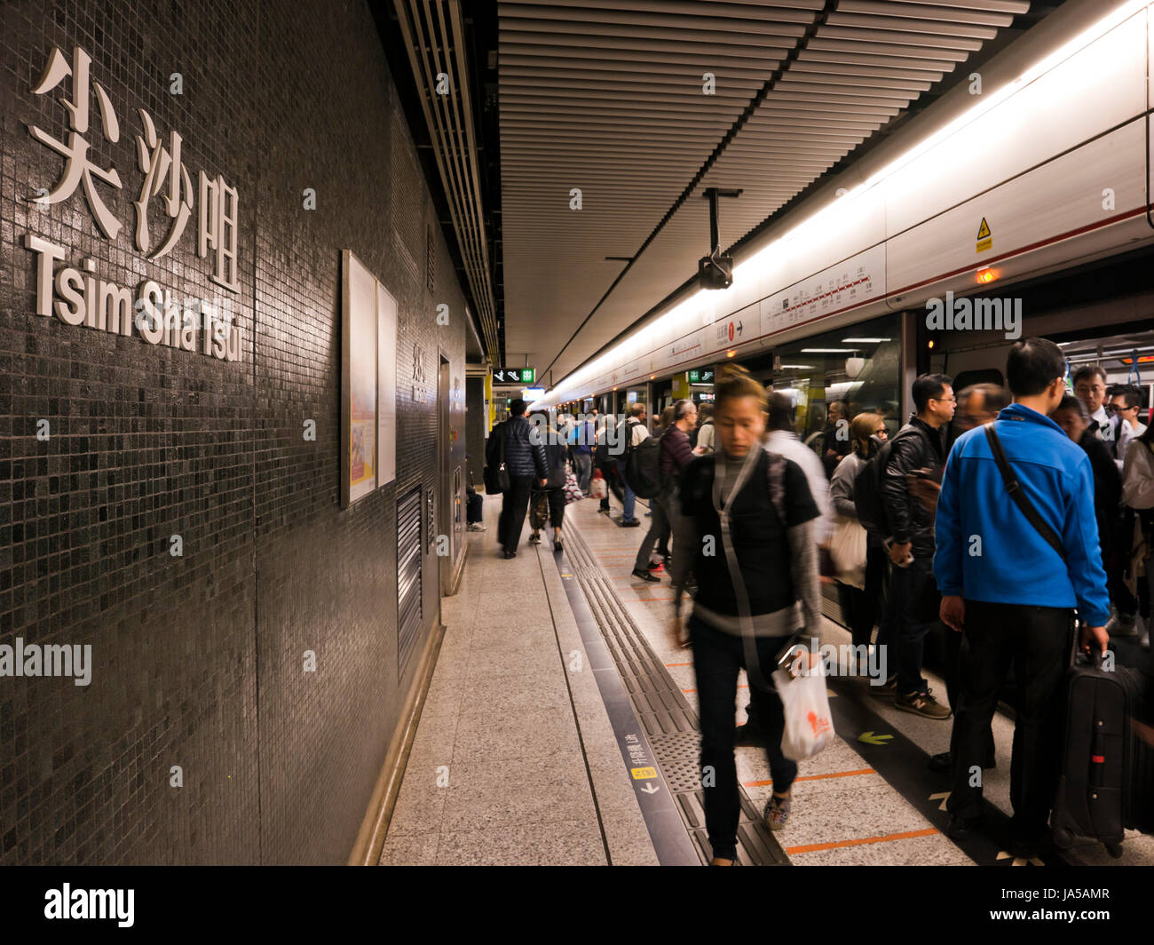 Vue horizontale de passagers à marcher le long de la plate-forme de l'EXAMEN À MI-PARCOURS, Mass Transit Railway, à Hong Kong, Chine. Banque D'Images