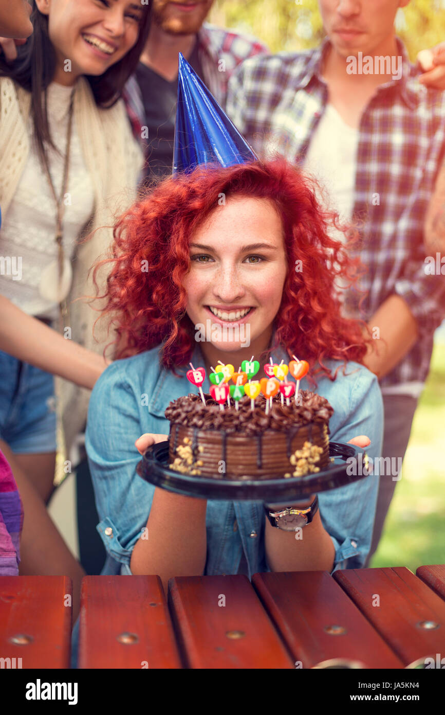 Portrait of Girl holding anniversaire gâteau au chocolat à l'extérieur de nice dans la nature Banque D'Images