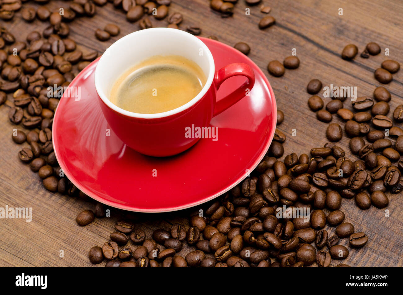 Espresso rouge sur une table en bois foncé Banque D'Images