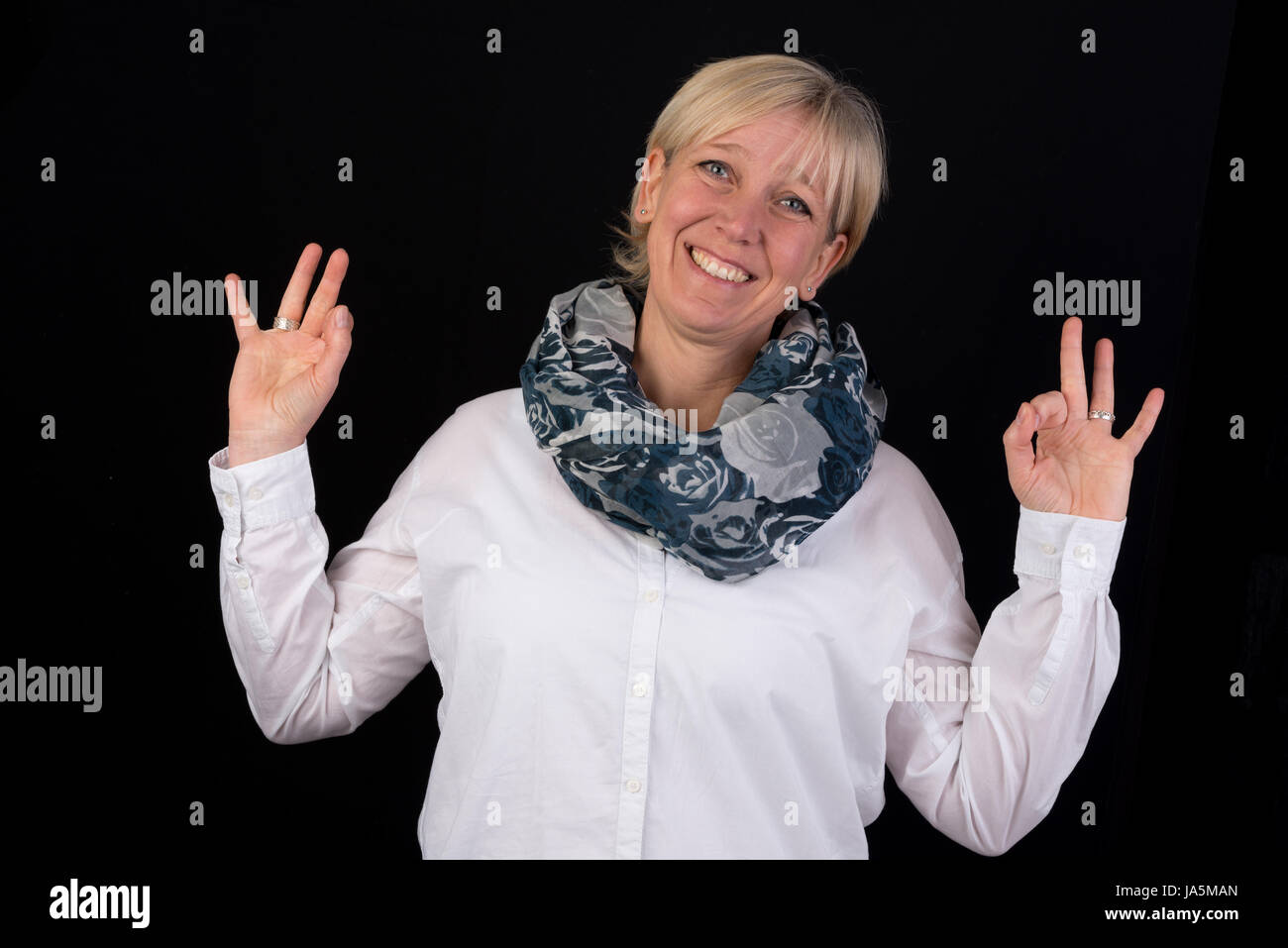 Belle blonde mature woman giving thumbs-up comme signe positif Banque D'Images