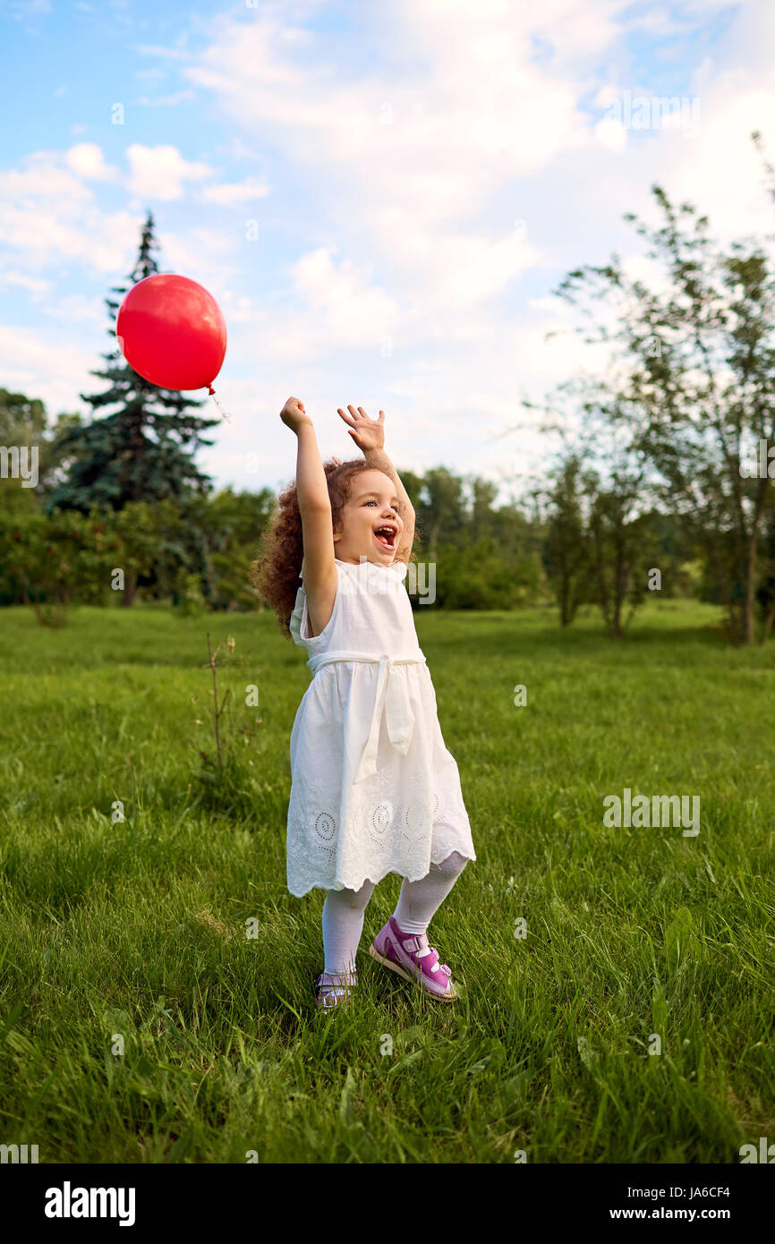 Enfant avec un ballon gonflable joue dans le parc. Banque D'Images