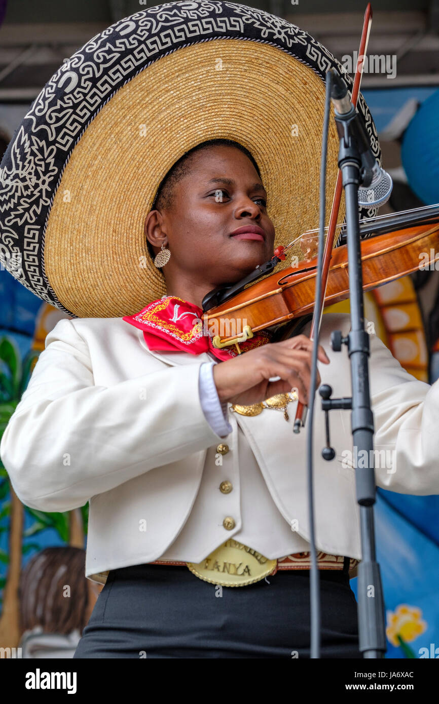 Violoniste mariachi femelle, jeune femme à la peau sombre, portant un musicien mariachi mexicain sombrero, habillé avec des vêtements traditionnels mariachi mexicain. Banque D'Images