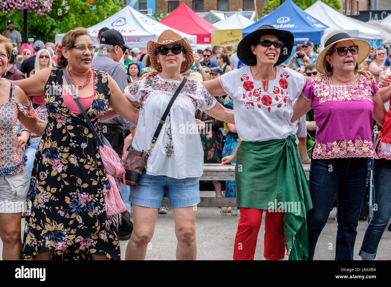 London, Ontario, Canada. 4 juin 2017. Fiesta London ! Festival mexicain célébrant les sons, la culture et la gastronomie du Mexique au Covent Garden Market, au centre-ville de London, Ontario. Organisé chaque année, le festival rassemble une variété d'artistes, de danseurs folkloriques colorés, de chanteurs et de divertissements de toute l'Amérique latine. Un groupe de femmes amies portant des chapeaux de paille embrassent face à la caméra, dansent et écoutent la musique live du concert et passent un bon moment ensemble. Crédit : Rubens Alarcon/Alamy Live News Banque D'Images