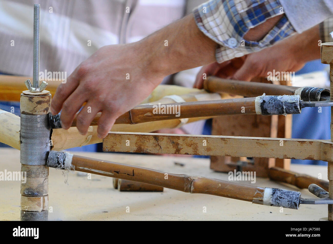 Les personnes sont considérées au cours de la fabrication de bicyclettes fait avec du bois de bambou pour promouvoir le transport écologique. Banque D'Images