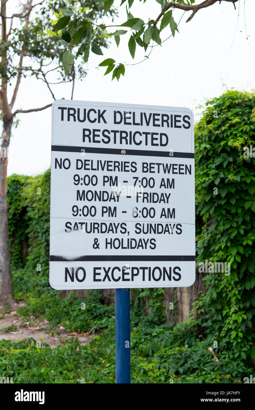 Délais de livraison camion restreint signe entre l'arrière d'un centre commercial et une zone résidentielle Banque D'Images