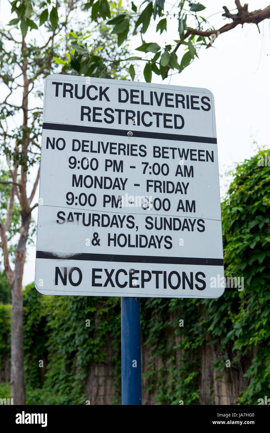 Délais de livraison camion restreint signe entre l'arrière d'un centre commercial et une zone résidentielle Banque D'Images